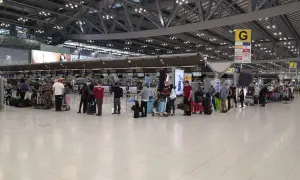 Menschen stehen in einer Schlange am Flughafen-Check-in. Gute **Kiwi com Erfahrungen** sind wichtig für entspanntes Reisen.