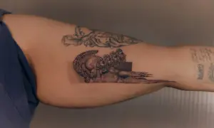 Tatuaż mikrorealizm przedstawiający antyczne hełmy i twarze, zlewające się w abstrakcyjny wzór.
