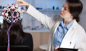 Lekarka zakłada pacjentce czepiec EEG, badając mózg. To przykład badań w neurologii, co to jest i jak działa.