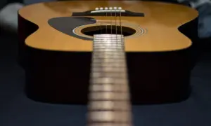 Nahaufnahme einer Akustikgitarre mit Fokus auf die Saitenlage.