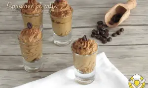 Delizioso spumone al caffè in bicchierini, guarnito con chicchi di caffè e cacao. Perfetto per un dolce momento.