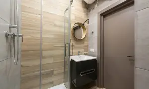 Modernos baños pequeños con ducha, lavabo flotante y espejo redondo.