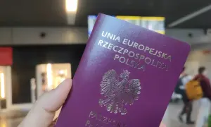 Polski paszport w dłoni, gotowy do podróży. Może to być początek drogi po wizę do Anglii.