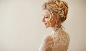 Eleganckie upięcia ślubne z perłami i kryształami, podkreślające urodę panny młodej w koronkowej sukni.