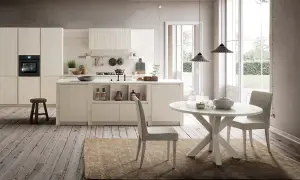Cucina chiara con isola centrale e tavolo rotondo. Ecco come abbinare il tavolo alla cucina per un look armonioso.