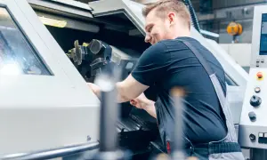 Operator maszyn CNC precyzyjnie ustawia narzędzie w maszynie.