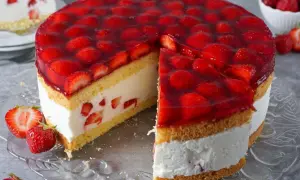 Eine saftige Erdbeer Torte mit viel frischen Erdbeeren und Sahne, die auf einem Tortenteller präsentiert wird.