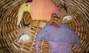 Due elefantini di stoffa colorati, perfetti per lavoretti con la stoffa per bambini. Uno arancione e giallo, l'altro viola e blu, con etichette "made by carla".