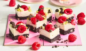 Kleine, cremige Kuchenstücke mit Himbeeren und Schokostückchen, perfekt für den Sommer.
