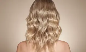 Piękne, falowane beżowe blond włosy opadające na ramiona.