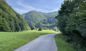 Droga wije się przez zieloną dolinę, otoczoną lasami. Idealne miejsce na przejażdżkę **velo Poprad**.