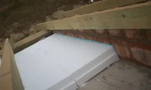 Izolacja ze styropianu na skosach dachu, przygotowana do dalszych prac.