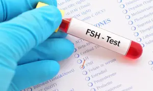 Ręka w niebieskiej rękawiczce trzyma probówkę z napisem "FSH - Test". Obok zaznaczono opcję FSH na liście badań.