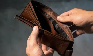 Puste, brązowe, skórzane etui na karty trzymane w dłoniach.