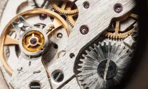 Detalle de un mecanismo de reloj, mostrando engranajes y el volante, que es un oscilador, en su interior.