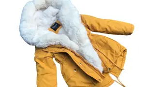 Żółta parka chłopięca z białym futrzanym obszyciem kaptura.