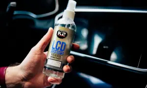 Dłoń trzyma płyn K2 LCD Display Cleaner, idealny do czyszczenia ekranu telefonu.