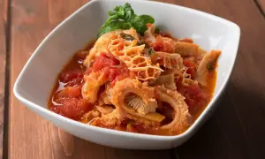 Trippa in umido con pomodoro e basilico, un piatto saporito che contiene ingredienti semplici ma gustosi.