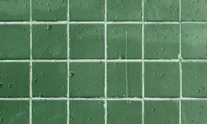 Gouttes d'eau sur un carrelage vert, montrant l'efficacité d'un traitement pour imperméabiliser un carrelage poreux.