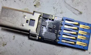Uszkodzony pendrive, który nie chce się sformatować. Widoczny układ scalony i złącze USB.