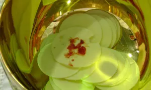 Hostie z plamą krwi, symbolizujące cud eucharystyczny w Indiach, w złotym naczyniu.