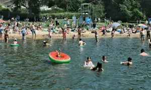 Tłum ludzi odpoczywa nad wodą, dzieci kąpią się w jednym z **jezior w Wielkopolsce**.
