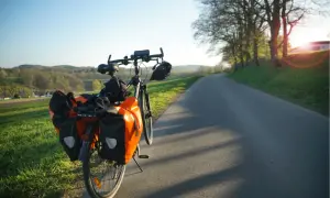 Rower z sakwami na drodze, idealny na długą podróż. Jak nie zasnąć w trasie? Wystarczy piękny widok i cel!