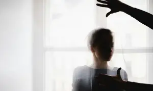 Cień dłoni nad głową i na piersi kobiety, symbolizujący moment, kiedy manipulant odpuszcza.