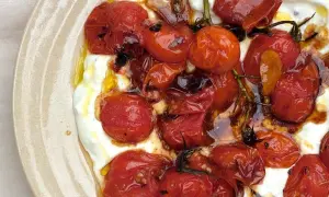 Geröstete Kirschtomaten auf cremigem Feta-Dip, beträufelt mit Olivenöl. Ein köstlicher Tomaten Feta Dip.