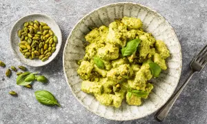 Gnocchis crémeux enrobés d'une sauce pesto onctueuse, parsemés de pistaches concassées et décorés de feuilles de basilic frais. Un délice !