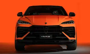 Pomarańczowy Lamborghini Urus SE z przodu, z czarnymi detalami i agresywnym grillem, na tle jaskrawej pomarańczy.