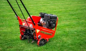 Czerwony aerator Weidemann gotowy do pracy, zapewniający profesjonalną rekultywację trawnika.