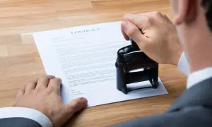 Un uomo timbra un contratto, un accordo "visto e piaciuto" che sigilla un impegno.