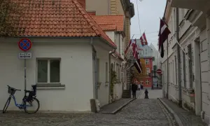 Urokliwa uliczka w Rydze, z łotewskimi flagami i brukowaną nawierzchnią. Idealne miejsce, by poczuć atmosferę miasta i odkryć, co zobaczyć.