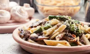 Makaron penne z kurczakiem, szparagami i pieczarkami w kremowym sosie.