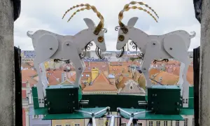 Dwie mechaniczne kozy na tle dachu poznańskiego ratusza.
