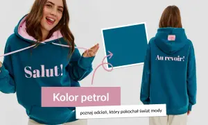 Młoda kobieta w bluzie w kolorze petrolowym z napisem "Salut!". Z tyłu bluzy napis "Au revoir!".