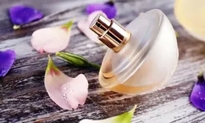 Perfumy w szklanej butelce, otoczone płatkami kwiatów. To idealny moment na refill, czyli uzupełnienie ulubionego zapachu.