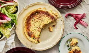 En saftig quiche lorraine med en gyllene skorpa, serverad med en fräsch sallad.