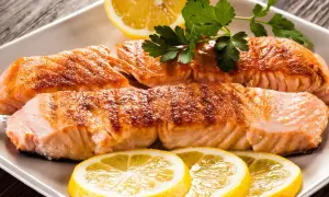 Filetti di salmone succulenti, cotti alla perfezione, con fette di limone e prezzemolo. Un piatto che fa pensare al salmone in gravidanza, ricco di omega-3.