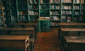 Stare ławki i regały pełne książek tworzą nostalgiczny motyw starej biblioteki lub klasy.