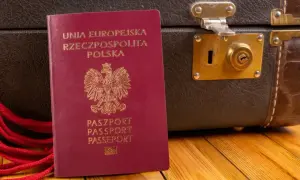 Czerwony paszport RP i stara walizka. Czy do Czarnogóry potrzebny jest paszport? Tak, ten dokument jest niezbędny do podróży.