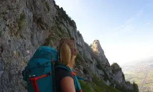 Wanderin auf dem Salzburger Hochthron, mit Blick auf steile Felsen und das Tal.