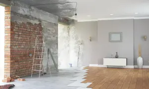 Renovación de casas con encanto: ladrillo visto, escalera, rodillo y suelo de madera en proceso.