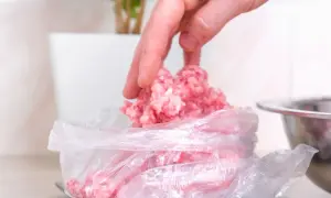 Dłoń wkłada mięso mielone do woreczka na wadze. Tak, mięso mielone można mrozić, by zachować jego świeżość.