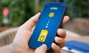Dłoń trzyma smartfon z ekranem pokazującym ikonę karty SIM i symbol chipa, symbolizujące kartę eSIM.