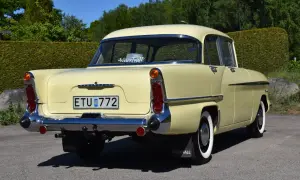En ljusgul Vauxhall Victor från 1950-talet, en klassisk modell, står parkerad utomhus.