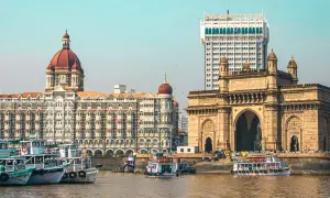 Brama Indii i hotel Taj Mahal Palace w Mumbaju, Indie. Wokół pływają łodzie.