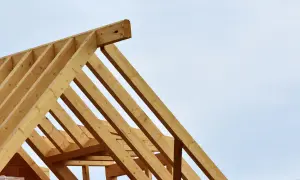 Drewniane belki tworzą konstrukcję więźby dachowej, gotową do pokrycia.