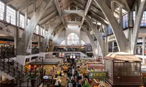 Das Innere der Markthalle, ein Wahrzeichen von Wrocław, mit seinen beeindruckenden Betonbögen und dem lebhaften Treiben der Marktstände.